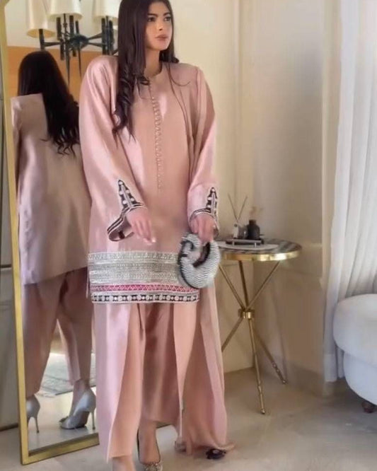 Woman in a pink traditional outfit standing in front of a mirror.