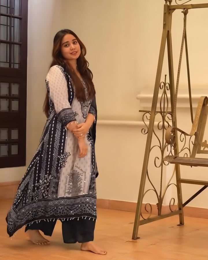 Woman in a traditional outfit standing in a room with wooden floor and decorative elements.