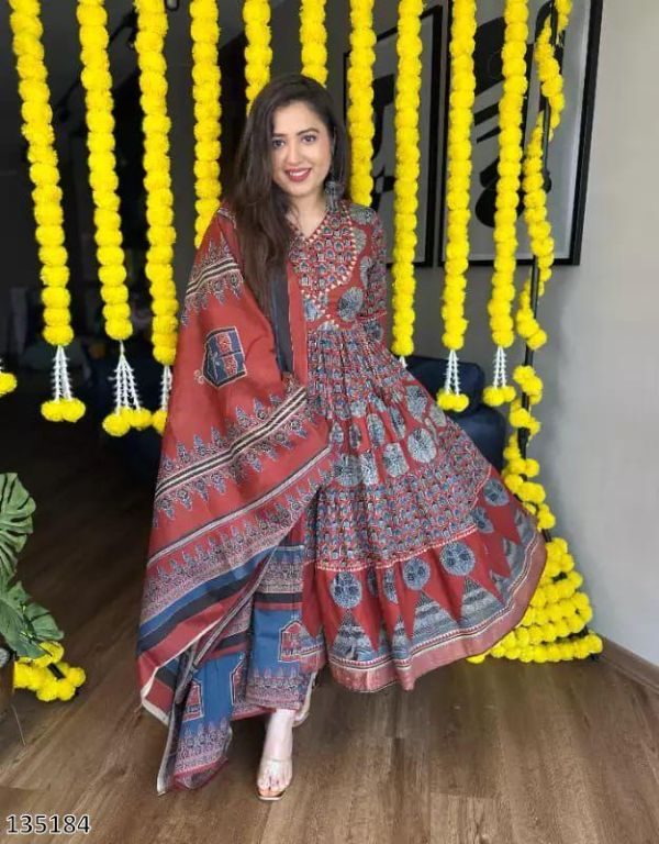 Woman in traditional outfit sitting in a decorated space with yellow flowers.