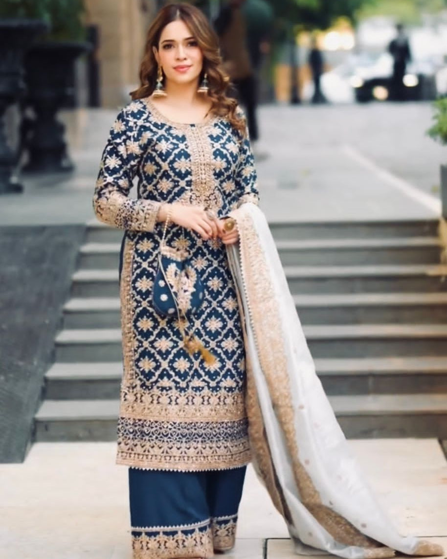 Woman in a traditional embroidered outfit standing on a city street.