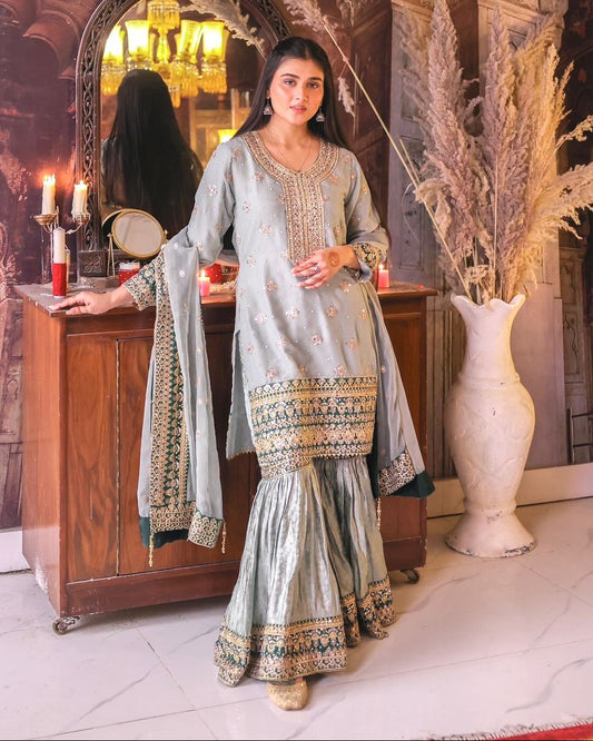 Woman in traditional outfit standing in an ornate interior setting