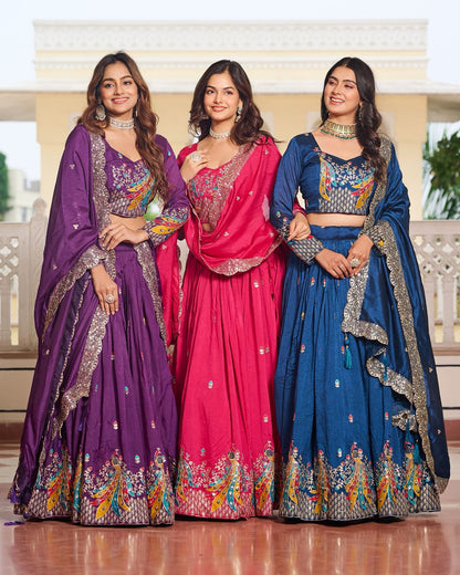 Three women in colorful traditional outfits standing together indoors.