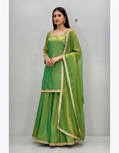 Green traditional outfit with matching dupatta on a gray background
