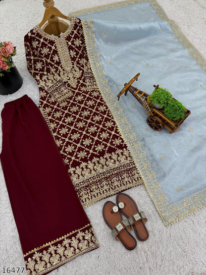 Maroon and gold embroidered dress with matching skirt on a light blue fabric background.