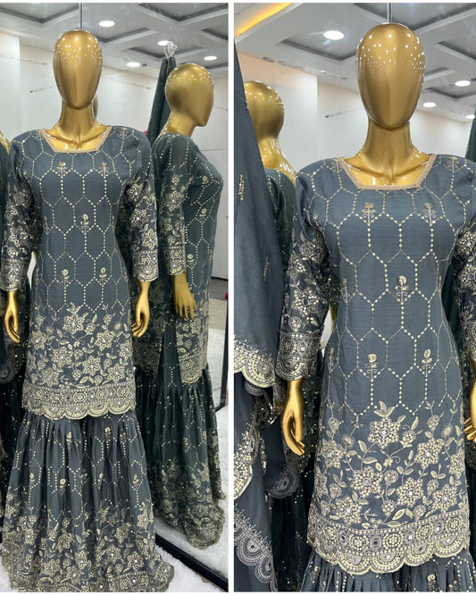 Gray traditional outfit with gold embroidery on a mannequin in a store setting.