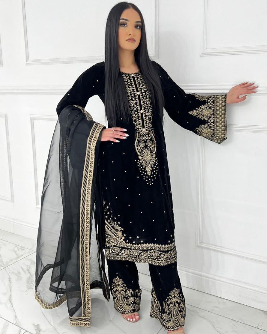 Woman wearing a black embroidered traditional outfit with a white background