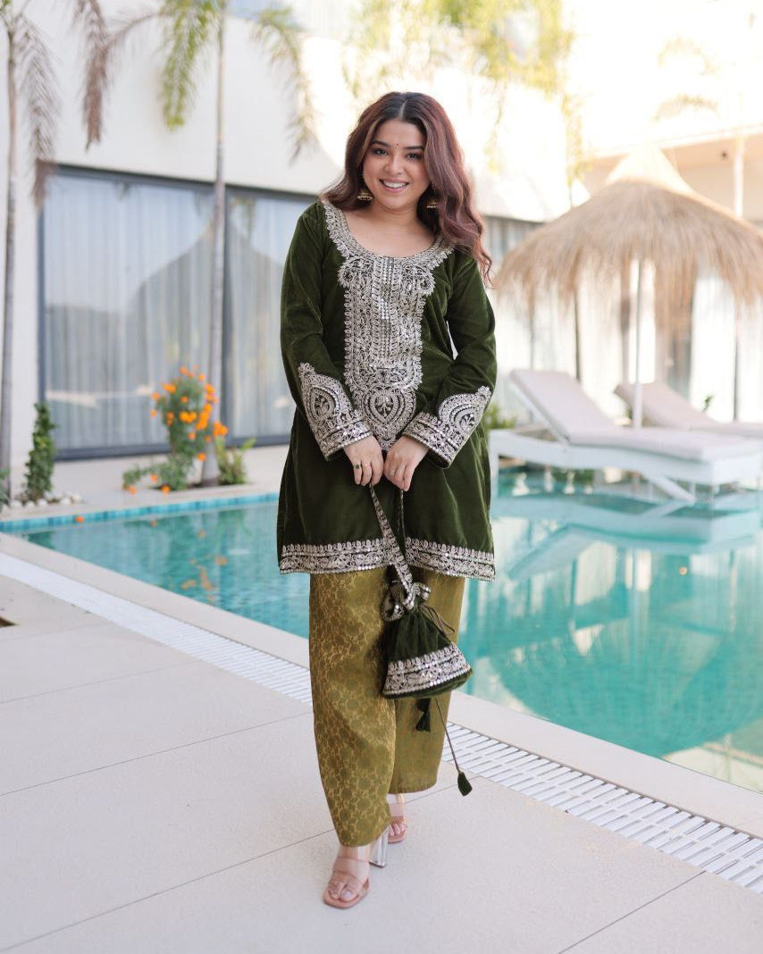 Woman in a green traditional outfit standing by a pool