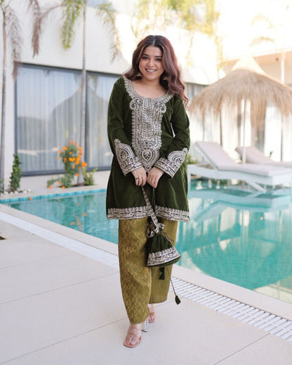 Woman in a green traditional outfit standing by a pool