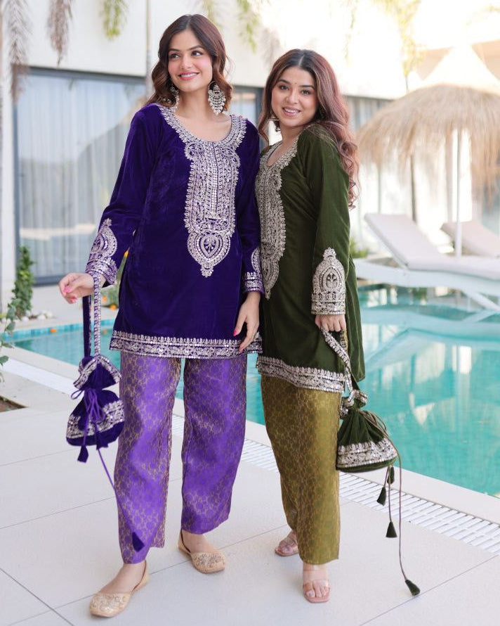 Two women in traditional outfits standing by a poolside.