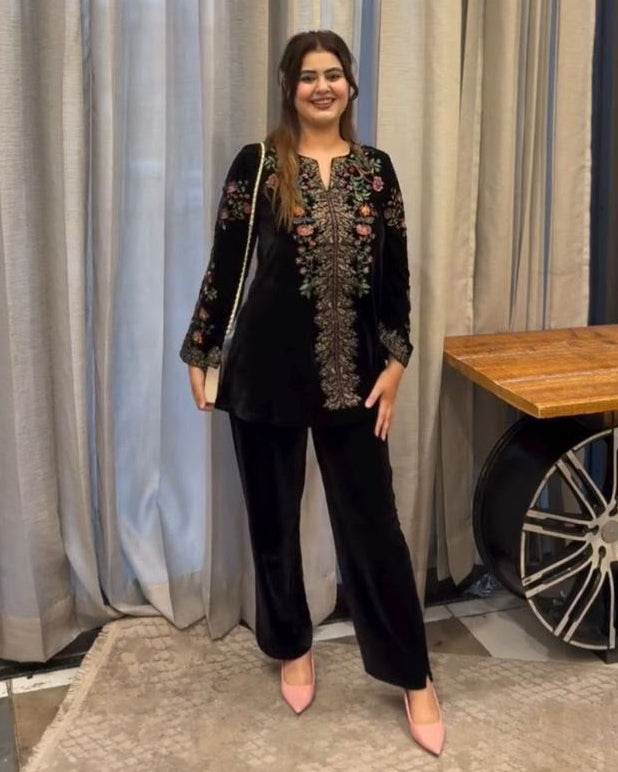 Woman standing in a room with curtains and a wooden table.