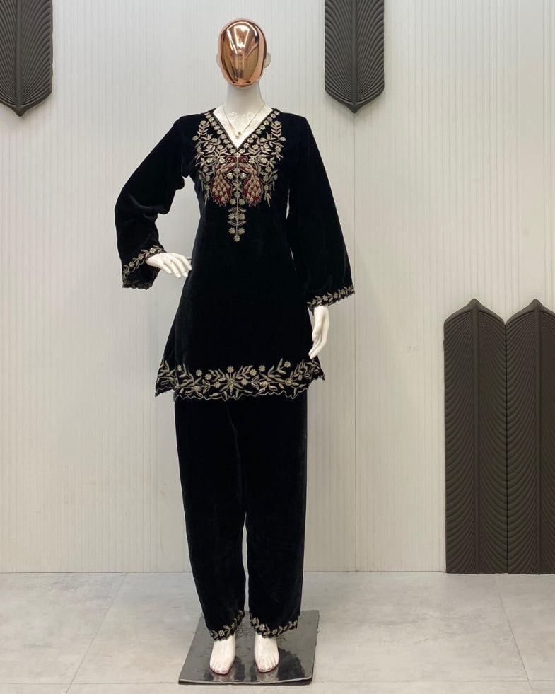 Mannequin wearing a black outfit with intricate designs in a store setting