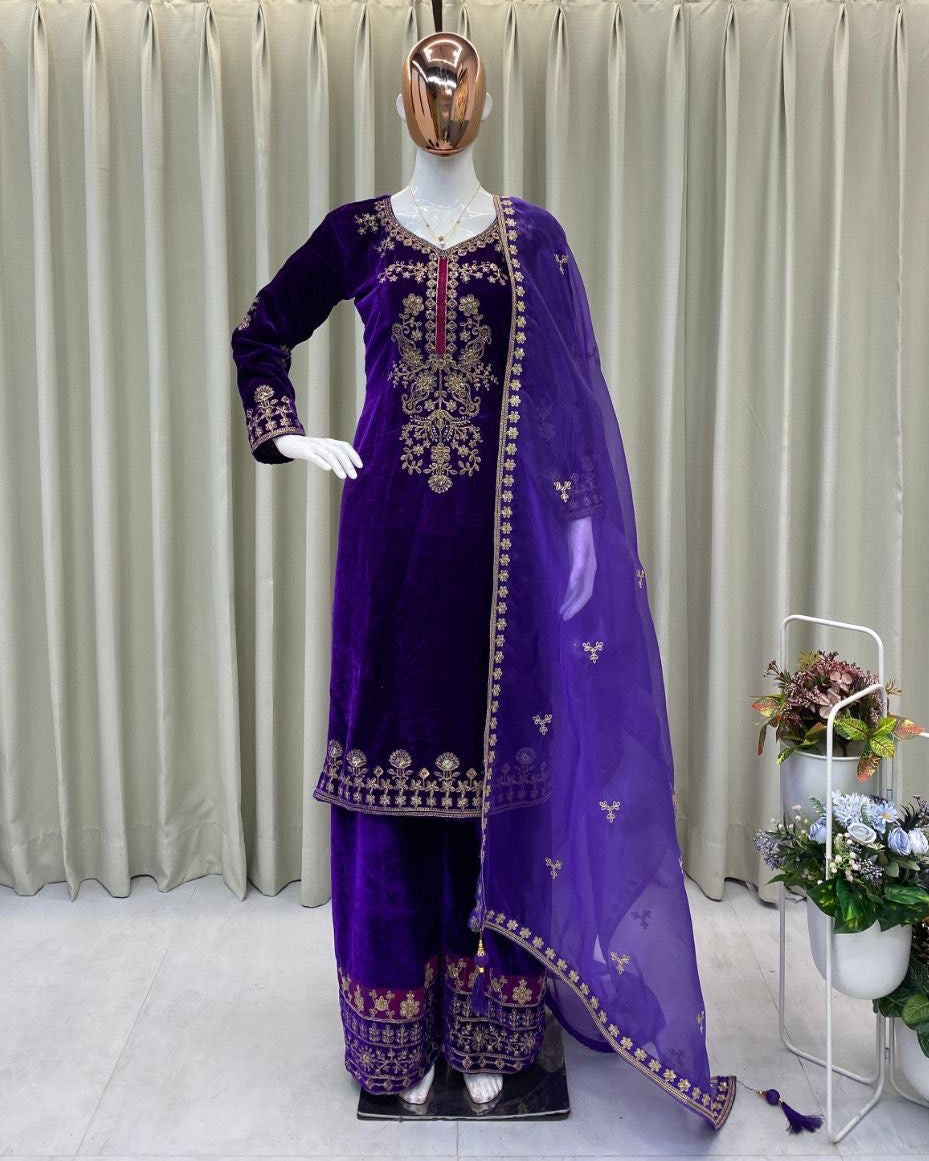 Purple embroidered traditional outfit on a mannequin against a neutral curtain background